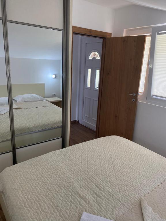 a bedroom with a mirror next to a bed at Apartments Boss in Budva
