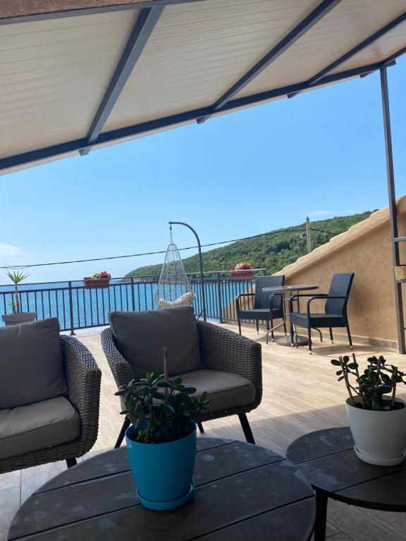 a patio with two chairs and a table with plants at Apartments Boss in Budva