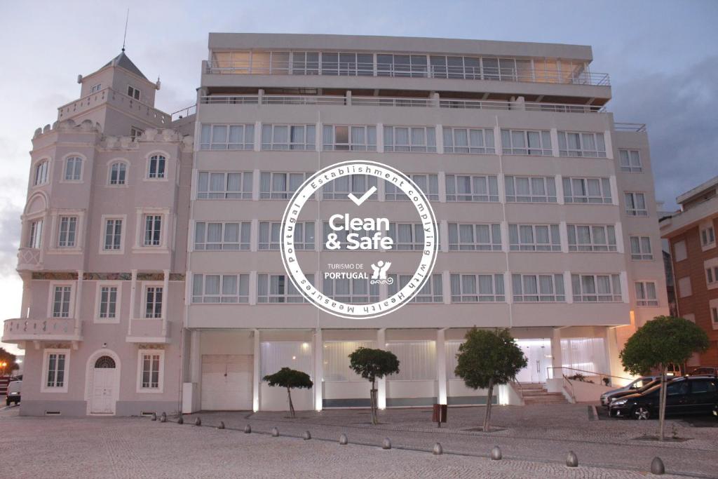 ein großes Gebäude mit einem Schild davor in der Unterkunft Costa de Prata Hotel in Figueira da Foz