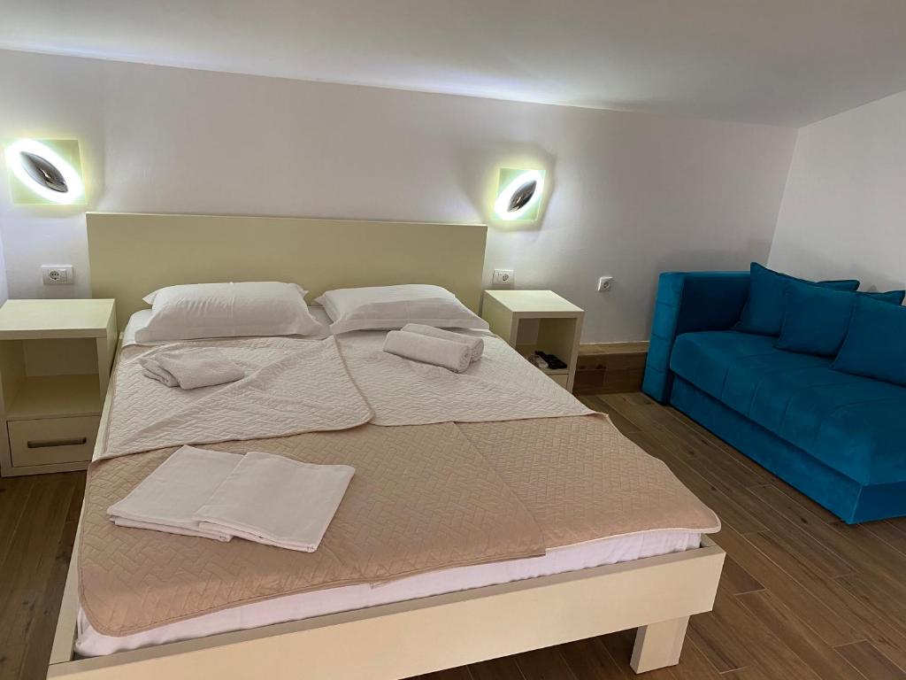 a bedroom with a bed and a blue couch at Apartments Boss in Budva
