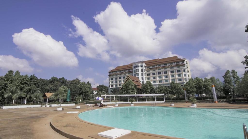 a hotel with a large swimming pool in front of a building at Arawan Riverside Hotel in Pakse