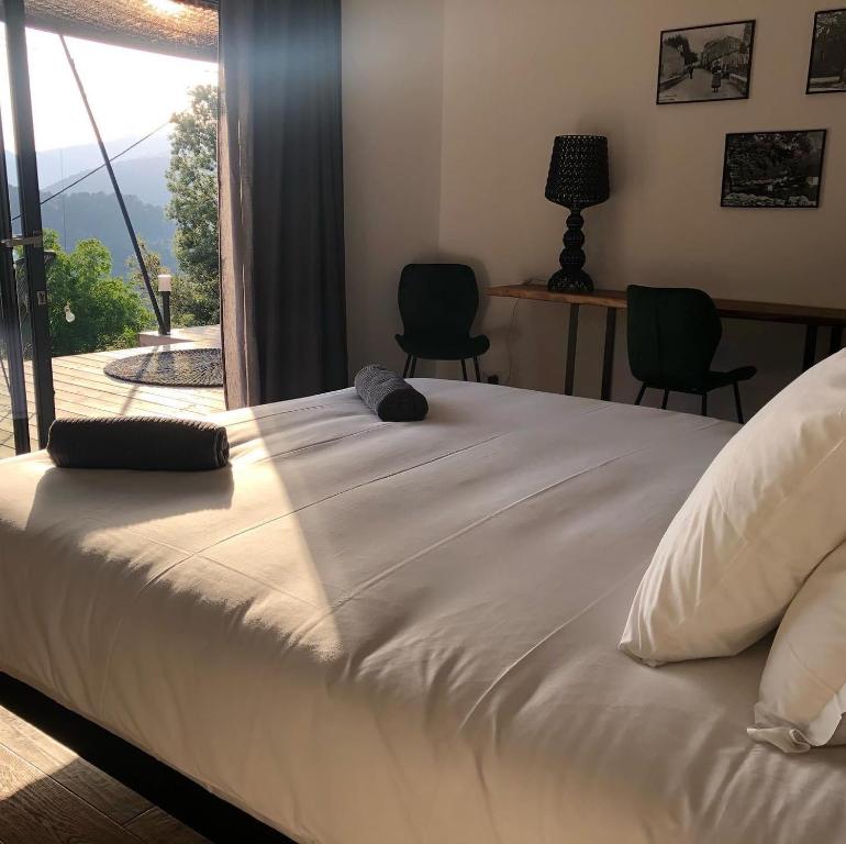 een groot wit bed in een kamer met een raam bij Casa Santa Lucia in Bocognano