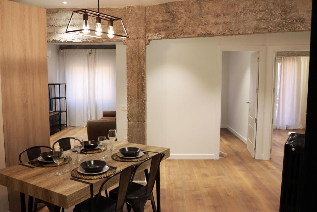 una sala da pranzo con tavolo e sedie in legno di Ático Industrial Céntrico, Reformado, Air-Acond, WiFi a Salamanca
