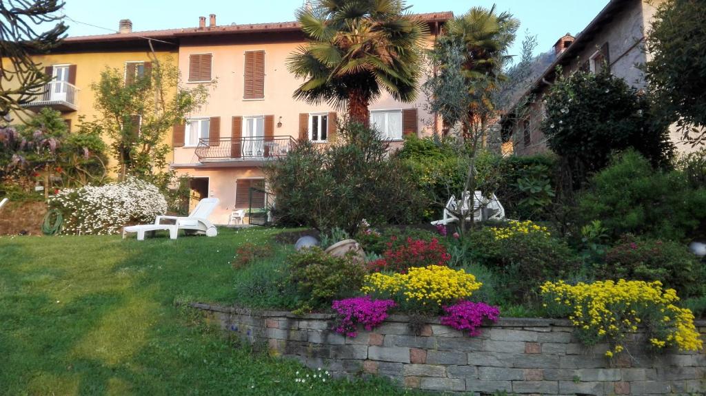 un jardín frente a una casa con flores en Bellavista, en Porto Valtravaglia