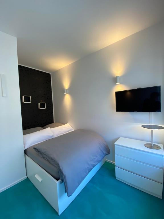 a bedroom with a bed and a flat screen tv at Ferienwohnung K1889 Rheine - Elin in Rheine