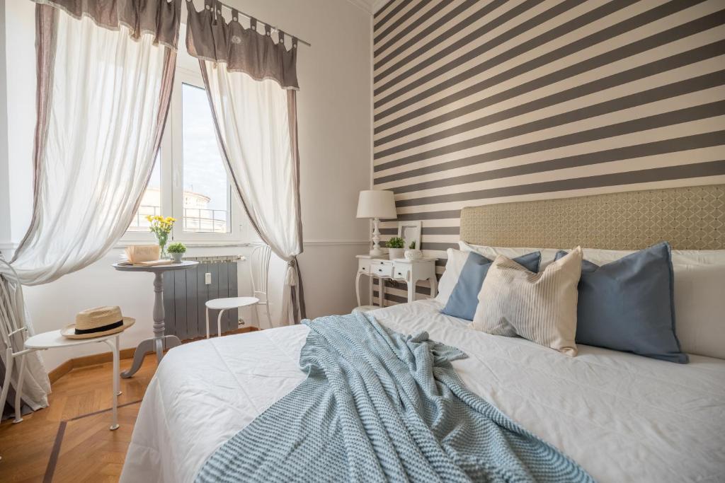 een slaapkamer met een bed met een gestreept hoofdeinde bij Suite 06 - NEW OPENING in Rome