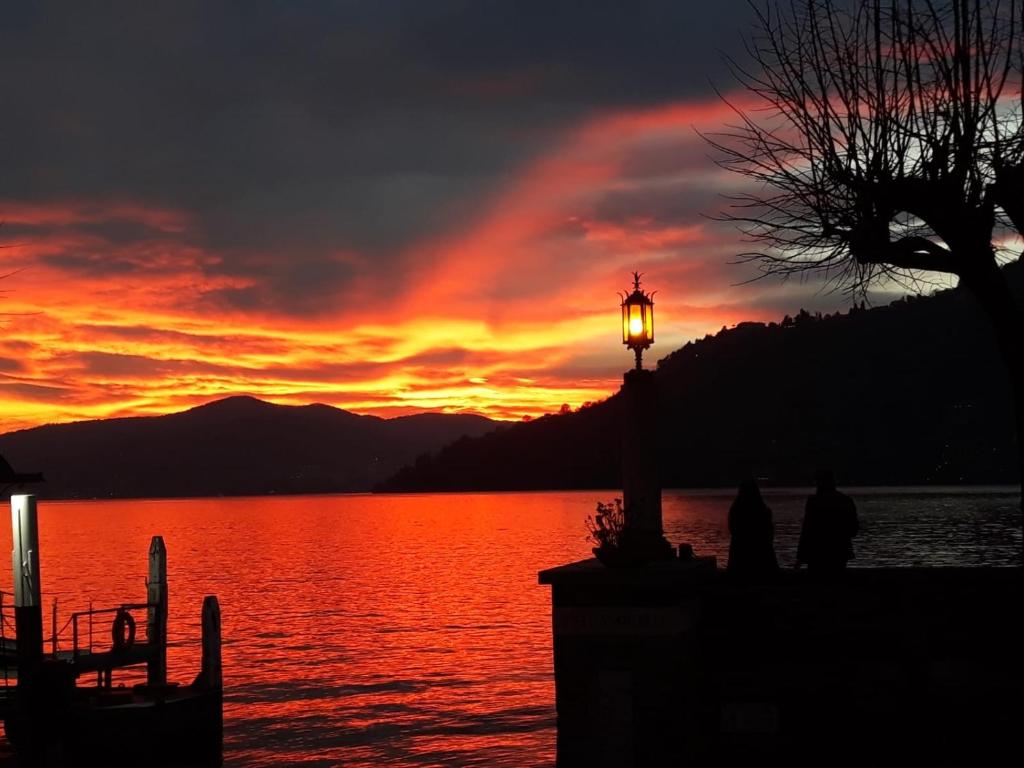 a sunset over a body of water with a street light at Casa Leonica in Torno