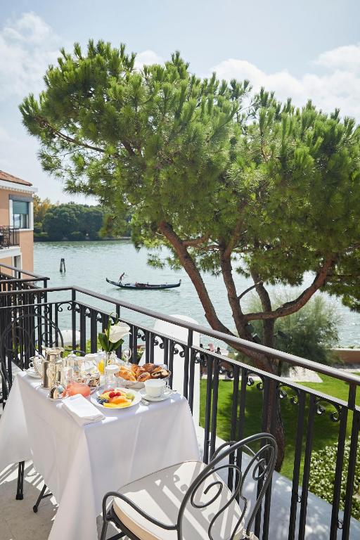 a table with food and a view of the water at Hotel Cipriani, A Belmond Hotel, Venice in Venice