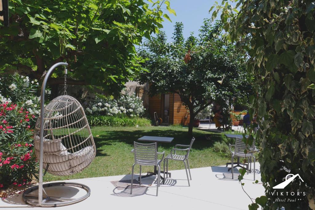 eine Gruppe von Stühlen und einem Tisch in einem Garten in der Unterkunft Hôtel Paul in Aix-en-Provence