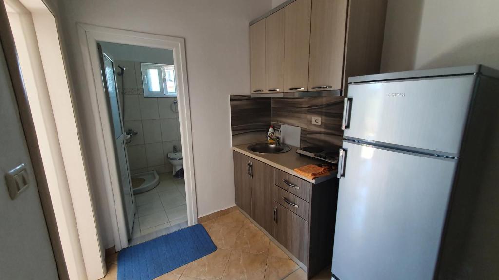 a small kitchen with a refrigerator and a sink at Villa Denis Ksamil in Ksamil