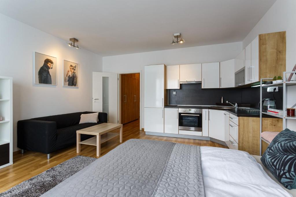 salon z łóżkiem i kuchnią w obiekcie Golden Apartments Rezidence Nová Karolina w Ostravie