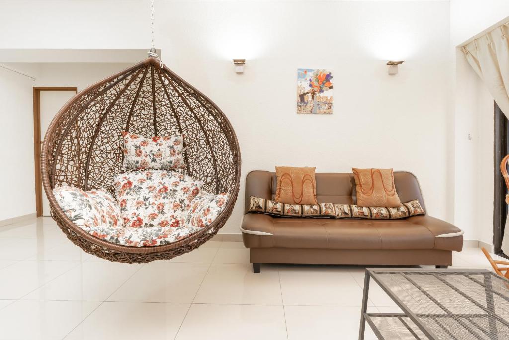um baloiço numa sala de estar com um sofá em DELUXE Suite Seaview Batu Ferringhi 2304 - 2 Rooms em Batu Ferringhi