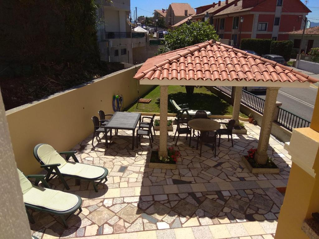 un patio con sedie e tavoli e un padiglione di Casa Marisma Xacobeo a Sanxenxo