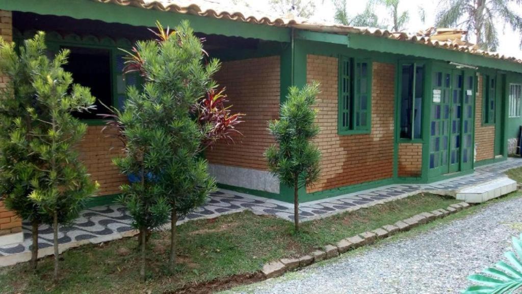 une maison avec des arbres devant elle dans l'établissement Chacara Descanso do Rei, à Vinhedo