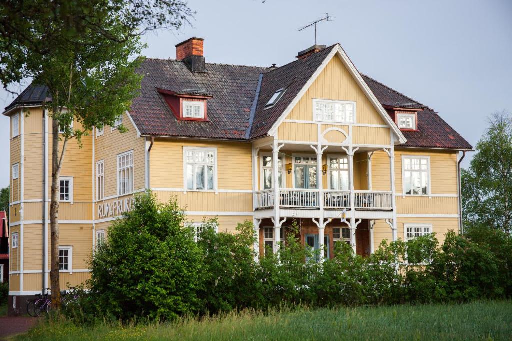 una gran casa amarilla con techo negro en STF Tre Björnar B&B, en Älvdalen