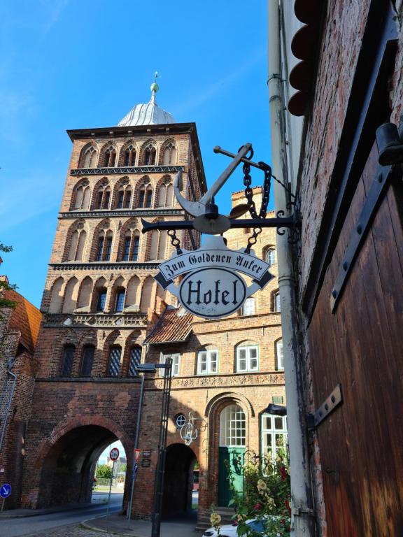 a building with a clock tower with a sign on it at Altstadthotel Zum Goldenen Anker in Lübeck