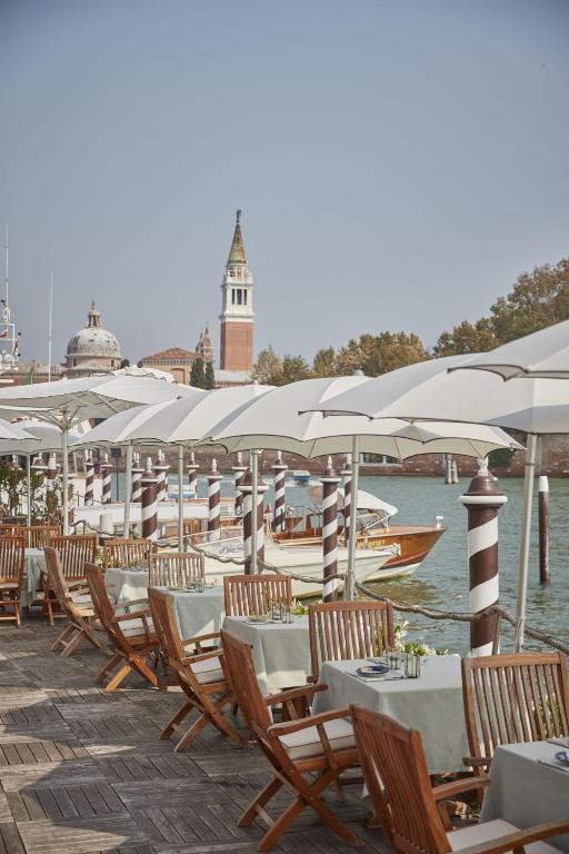 a row of tables and chairs with white umbrellas at Hotel Cipriani, A Belmond Hotel, Venice in Venice
