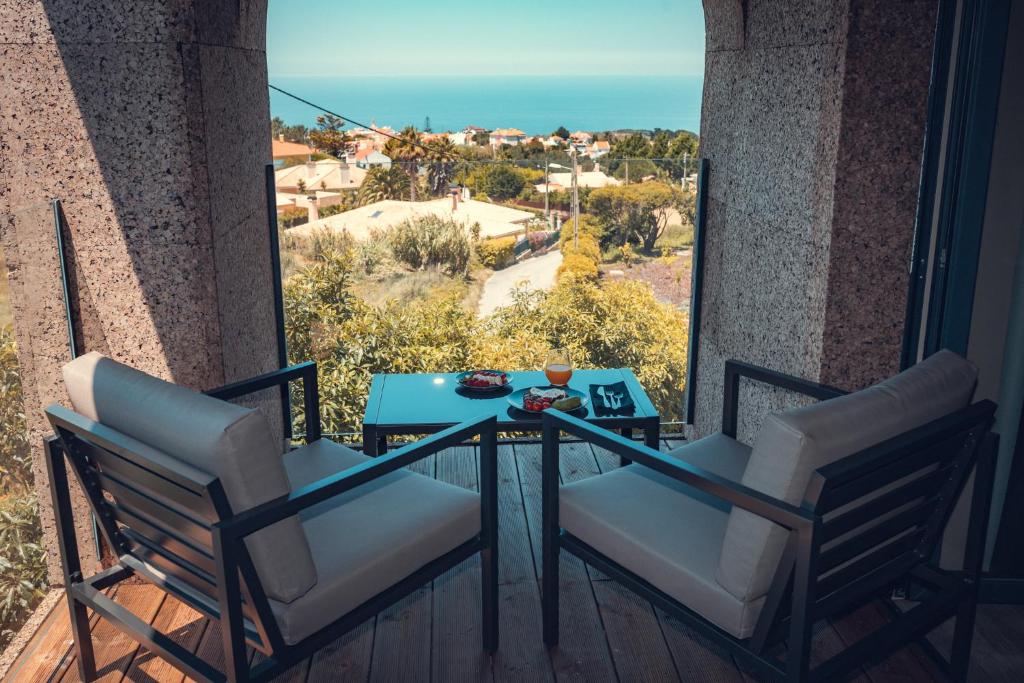 a table and chairs on a balcony with a view of the ocean at Charm Nature in Azoia