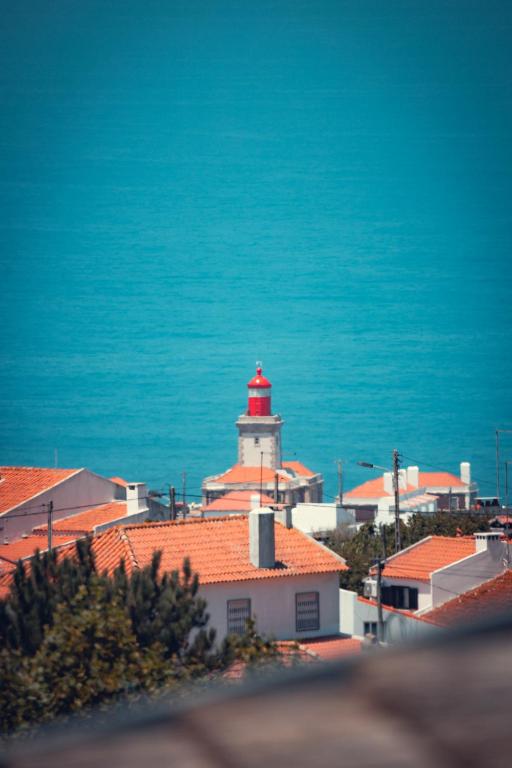 a red and white lighthouse on top of a building at Charm Nature in Azoia
