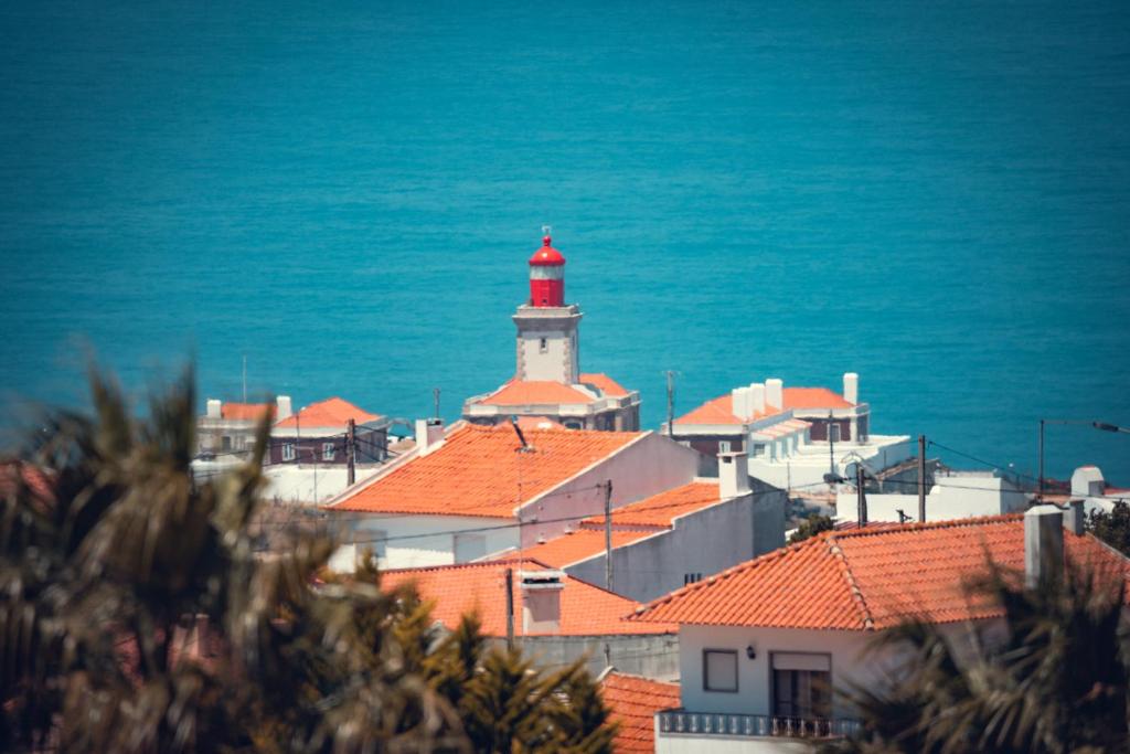 a red and white lighthouse on top of a city at Charm Nature in Azoia
