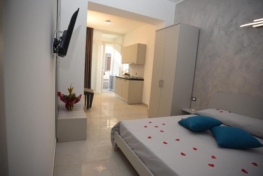 a bedroom with a large bed with blue pillows at Angelo Bianco Appartment in Porto Cesareo