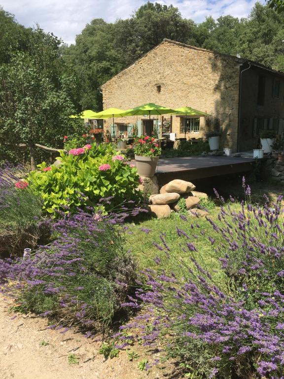 a garden with flowers in front of a building at Le Mas aux Arômes in Puget