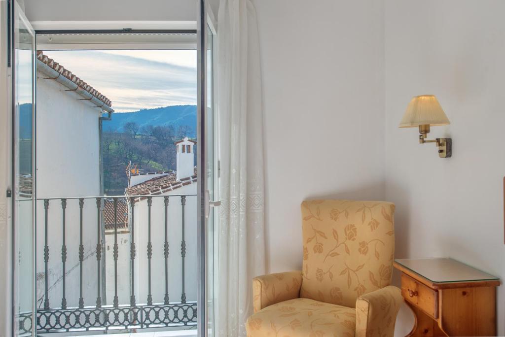 a room with a chair and a balcony with a view at Planta Baja Casa Carmen y Andrés in Faraján