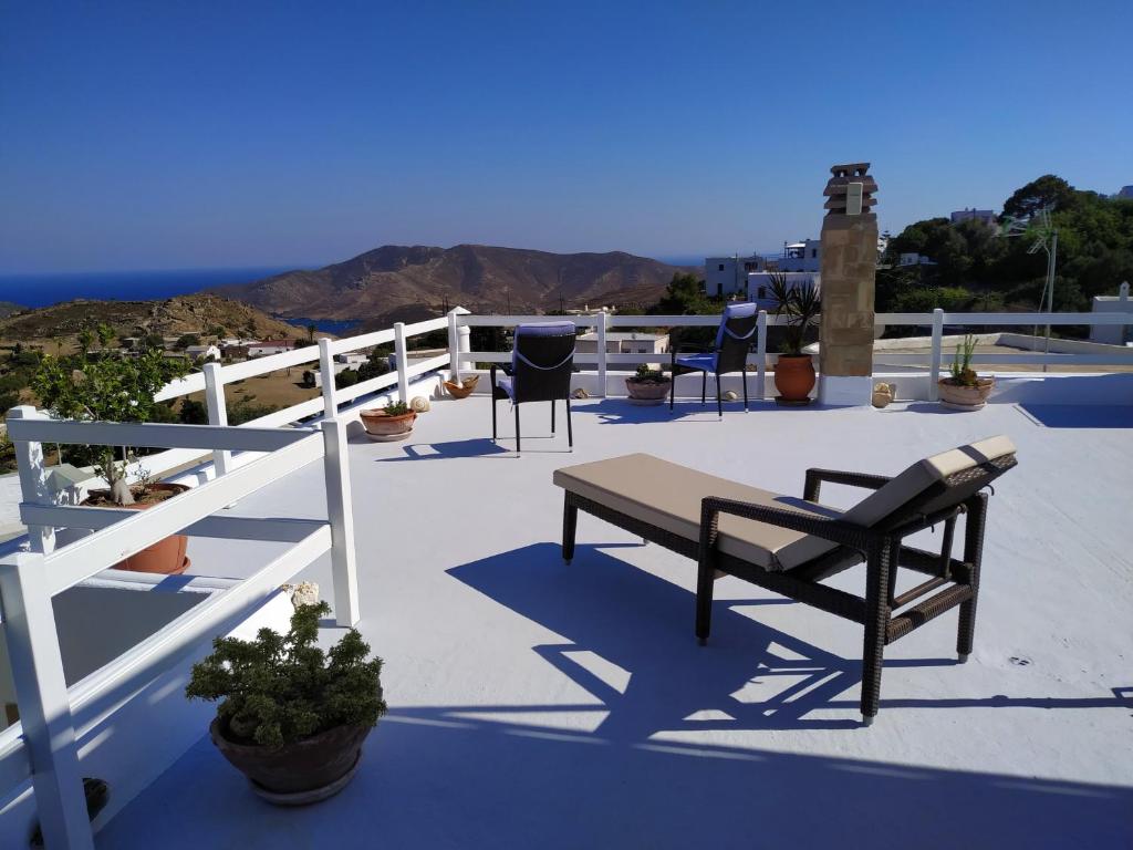 a patio with chairs and a bench on a roof at Manos House in Chora in Patmos