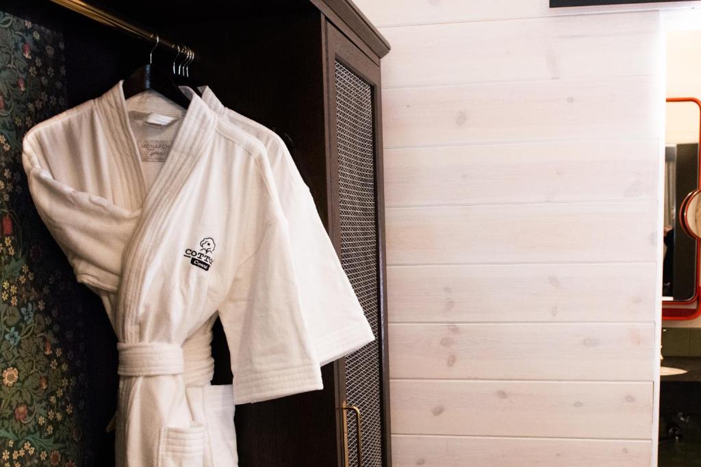 a white shirt hanging in a closet at Cotton Court Hotel, by Valencia Hotel Collection in Lubbock
