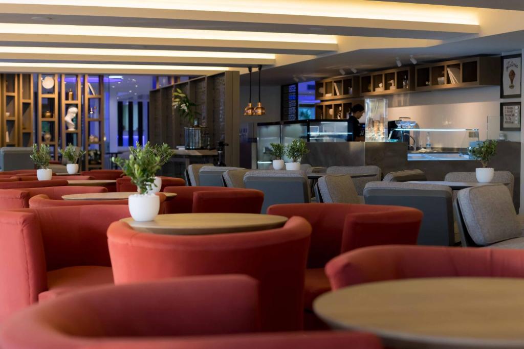 a restaurant with red chairs and tables at Tasia Maris Beach Hotel - Adults Only in Ayia Napa