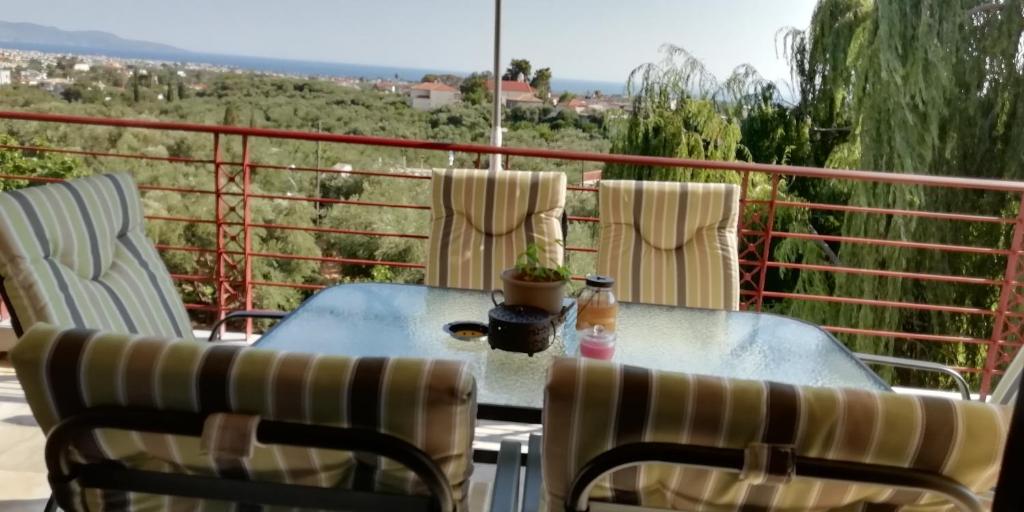 a table and chairs on a balcony with a view at Panorama house leika kalamatas in Kalamata