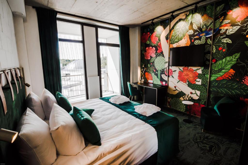 ein Schlafzimmer mit einem Bett mit einem Sofa und einem Fenster in der Unterkunft Ego SPA in Birštonas