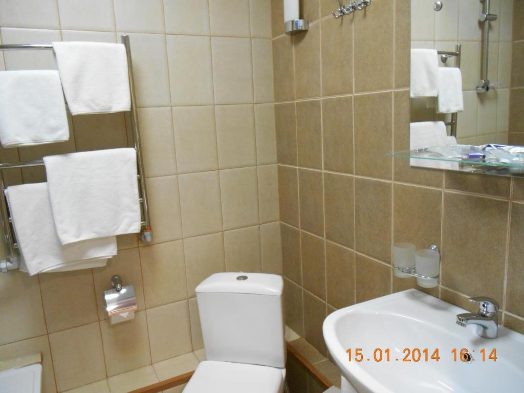 a white toilet sitting next to a bathroom sink at Pik Hotel in Ryazan