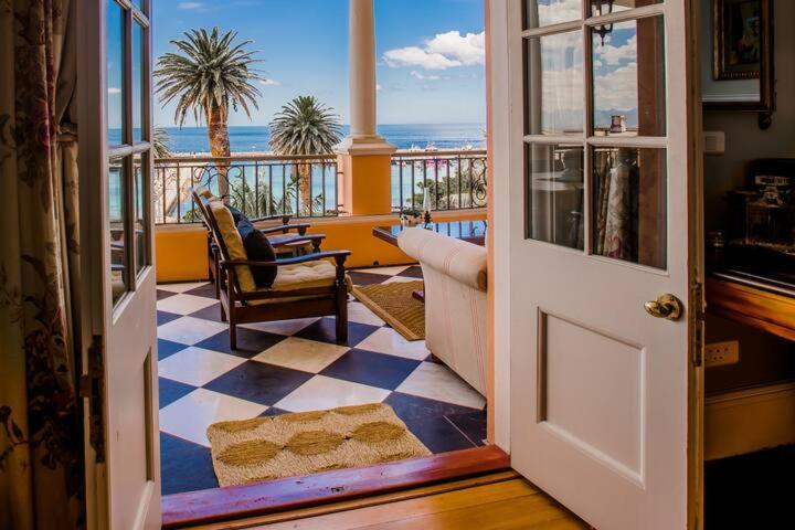 an open door to a balcony with a view of the ocean at Majestic Ocean View Retreat in Cape Town