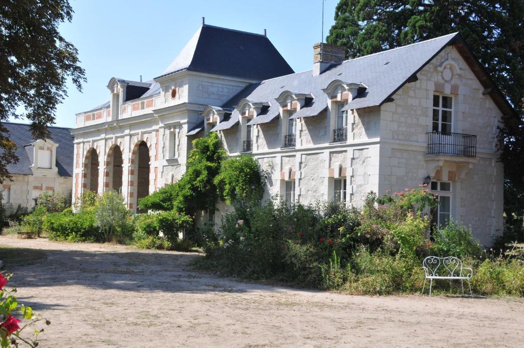 une grande maison avec un toit dans l'établissement La Terrasse de L'Orangerie du Château - Art Nouveau - GITE 2 Personnes, à Brain-sur-Allonnes