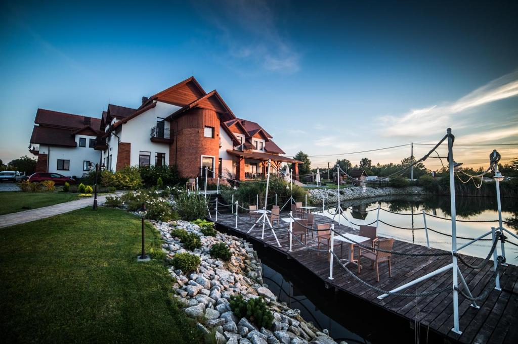 una casa con puerto deportivo junto a un río en Hotel Grodzisko, en Grodzisk Mazowiecki