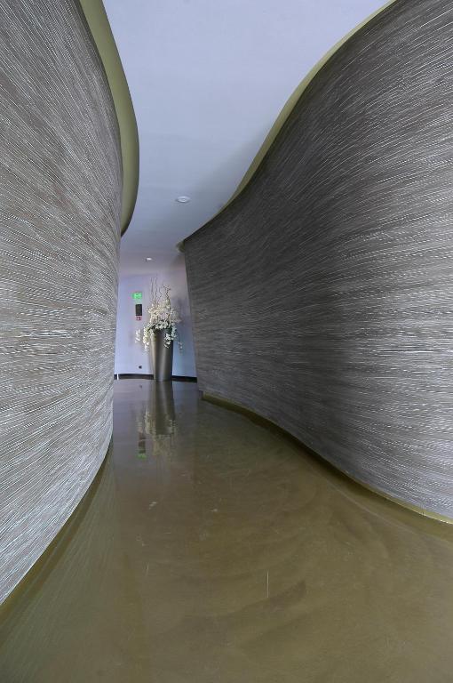 a hallway with a wall and a vase with flowers at Les Fleurs Boutique Hotel in Sofia