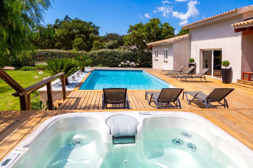 un bain à remous sur une terrasse à côté d'une piscine dans l'établissement Villa ARCA, à Porto-Vecchio