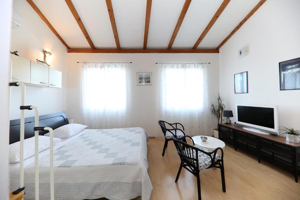a bedroom with a bed and a tv in a room at Puntamika studio in Zadar