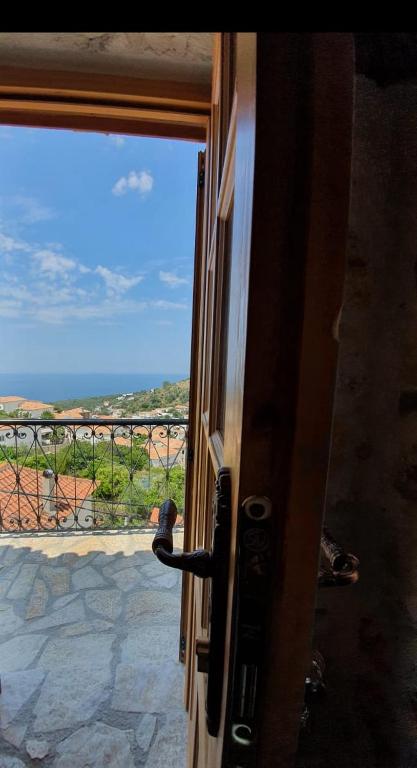 a person looking out of a door at a view at Roots Dhermi in Dhërmi