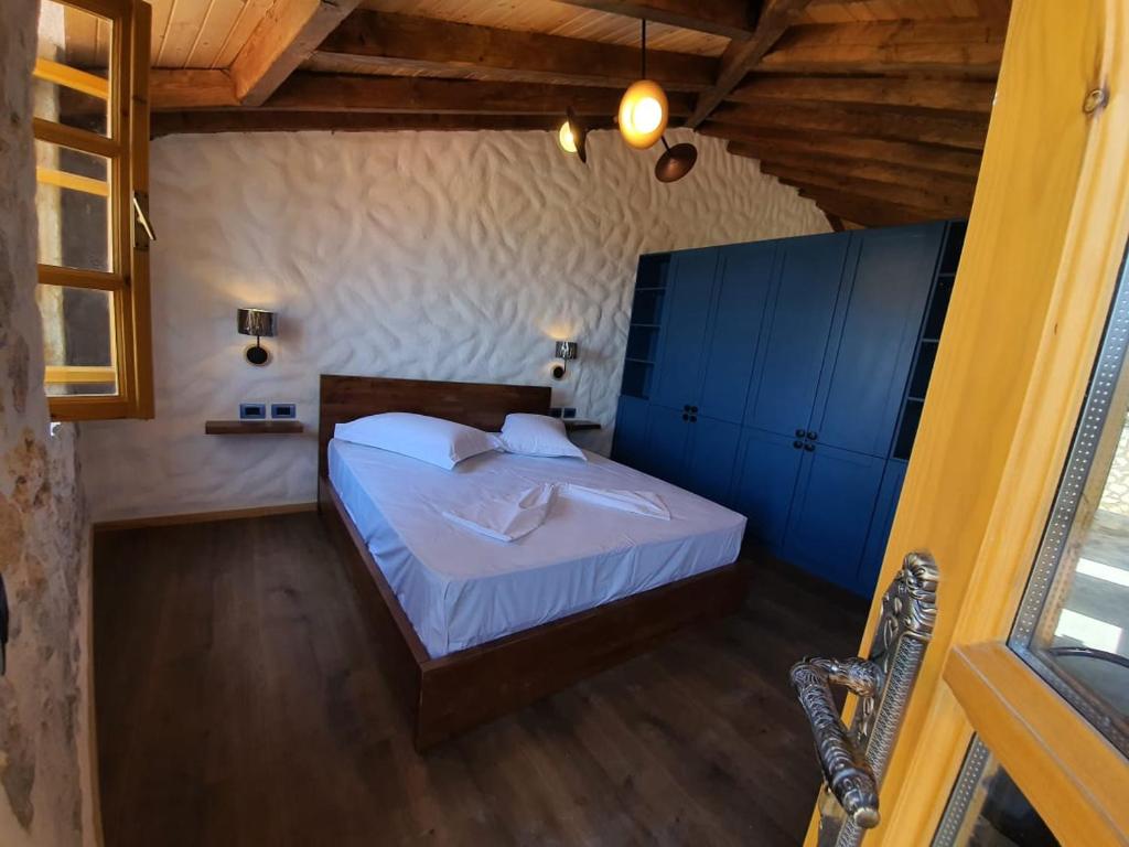 a bedroom with a bed with blue cabinets at Roots Dhermi in Dhërmi