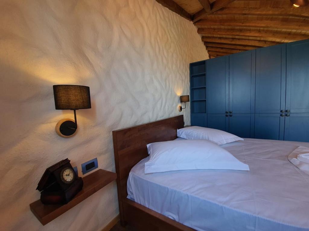 a bedroom with a bed with a clock on it at Roots Dhermi in Dhërmi