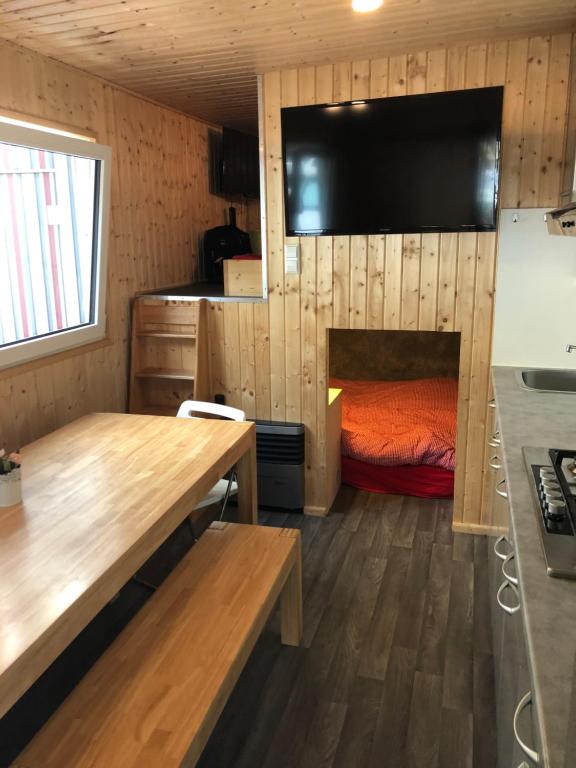 Cette petite chambre comprend un lit et une télévision à écran plat. dans l'établissement Zillerglückhütte - 5 Sterne Camping Aufenfeld, à Aschau