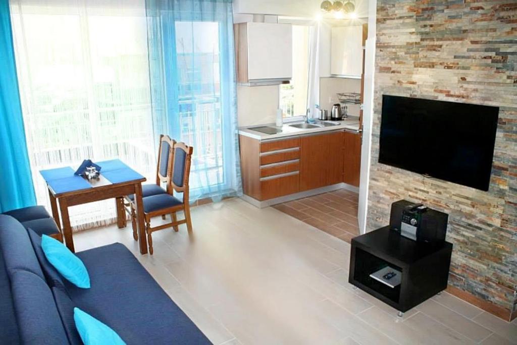 a living room with a couch and a kitchen at Royal Blue przy samym Morzu Plaży in Primorsko