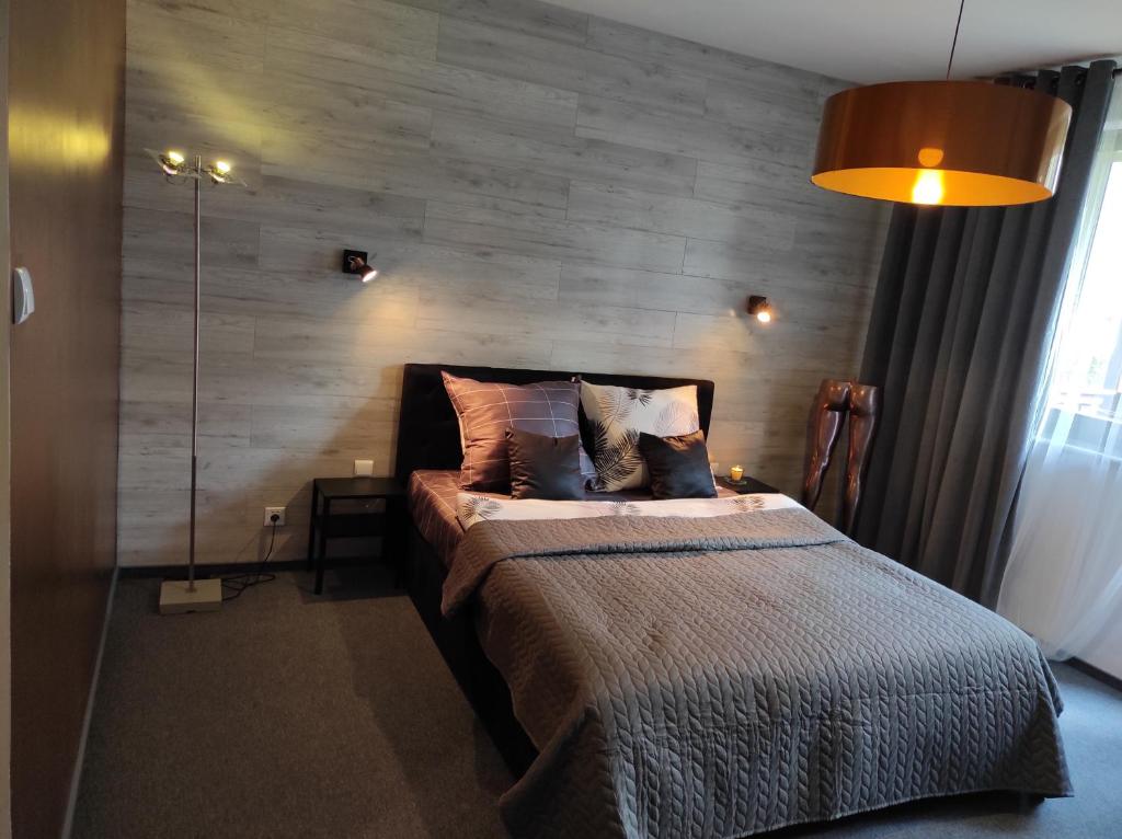 sypialnia z łóżkiem z drewnianą ścianą w obiekcie Heliosa Apart Gdańsk Kowale w Gdańsku