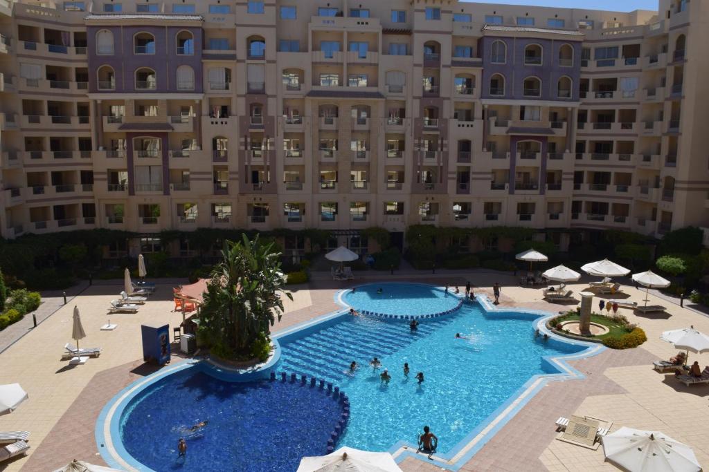 a large swimming pool in front of a large building at Florenza Khamsin 1 bedroom apartment with swimming pool view in Hurghada