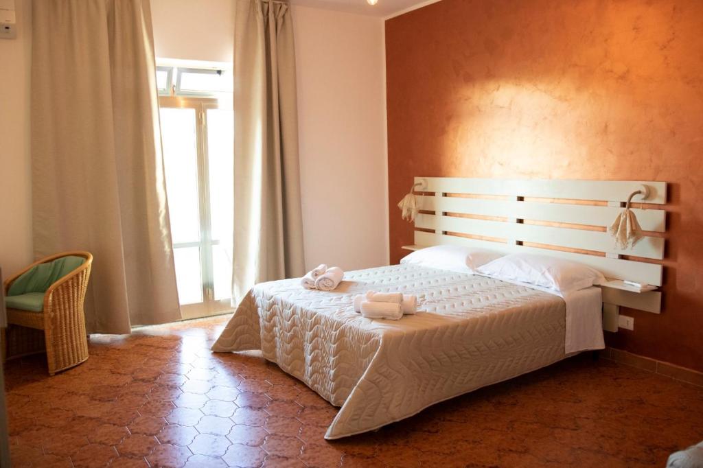 1 dormitorio con 1 cama con 2 toallas en Hotel Ristorante Scirocco, en Portopalo di Capo Passero