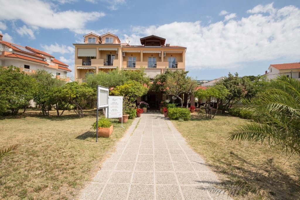 a walkway in front of a large building at Villa Tamaris in Rab
