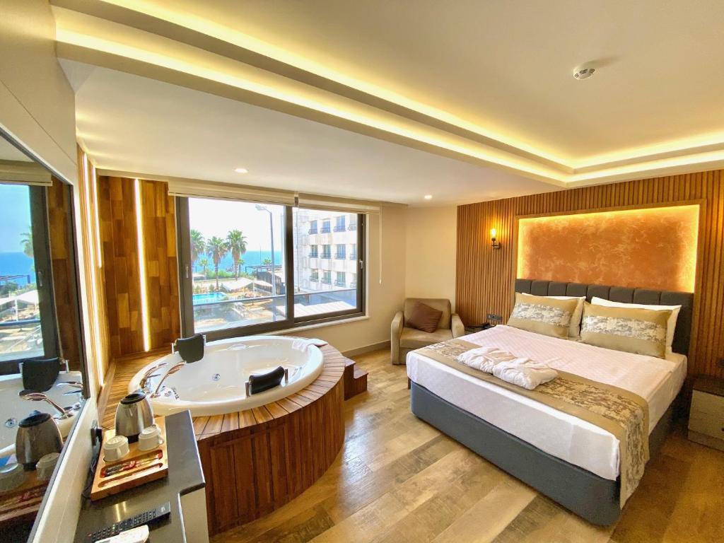 a bedroom with a tub and a bed with a view at Green Beyza Suites in Antalya