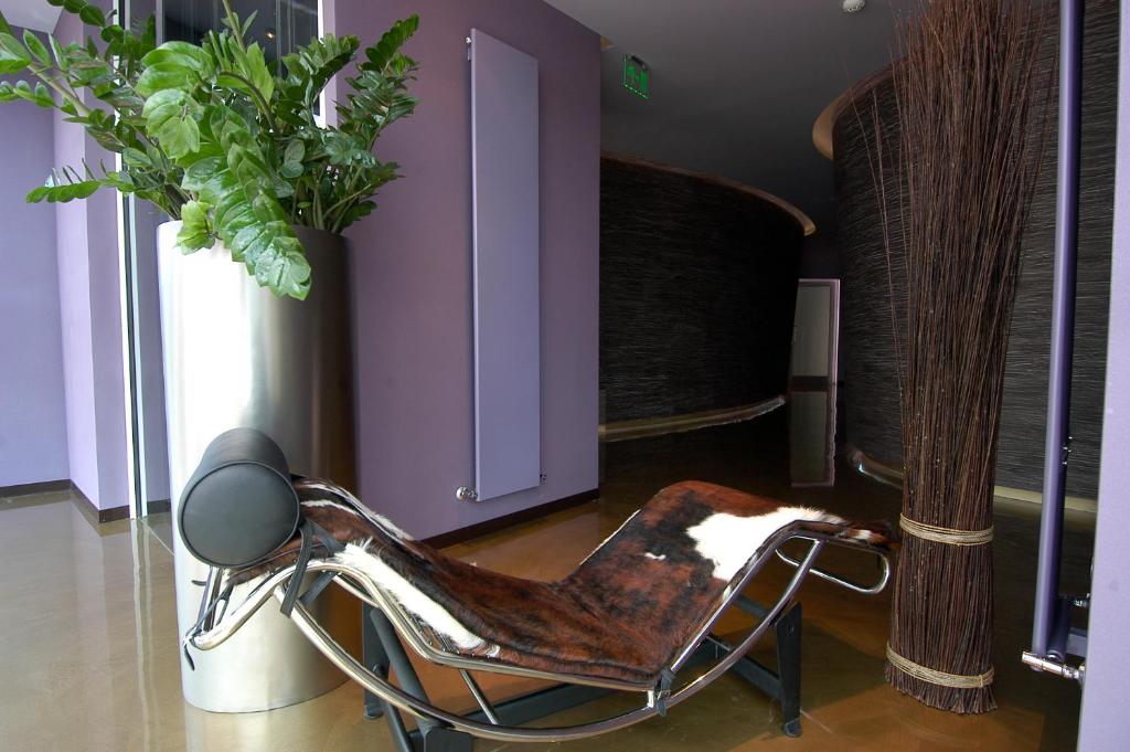 a chair in a room with a potted plant at Les Fleurs Boutique Hotel in Sofia